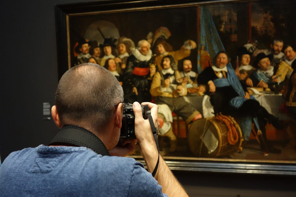 Mann fotografiert ein Gemälde in einem Museum urheberrechtlich erlaubt