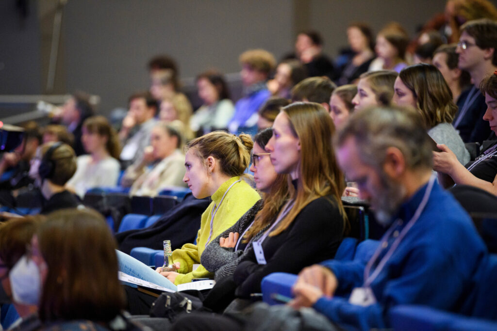 Seitlicher Blick ins Publikum: Konzentriert in Richtung Bühne schauende Konferenzgäste.