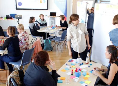 Teilnehmende eines Workshops bei kulturBidigital brainstormen an Tischen mit Klebezetteln oder bearbeiten gemeinsam Übungen an einem Whiteboard